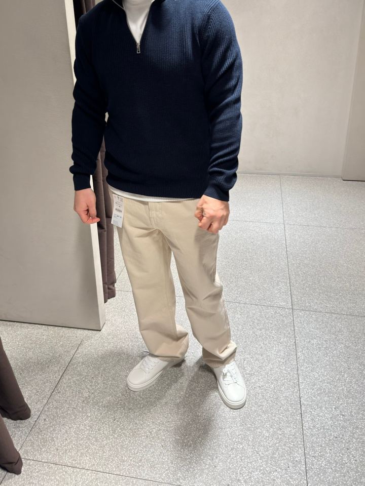 Navy half-zip sweater with cream trousers