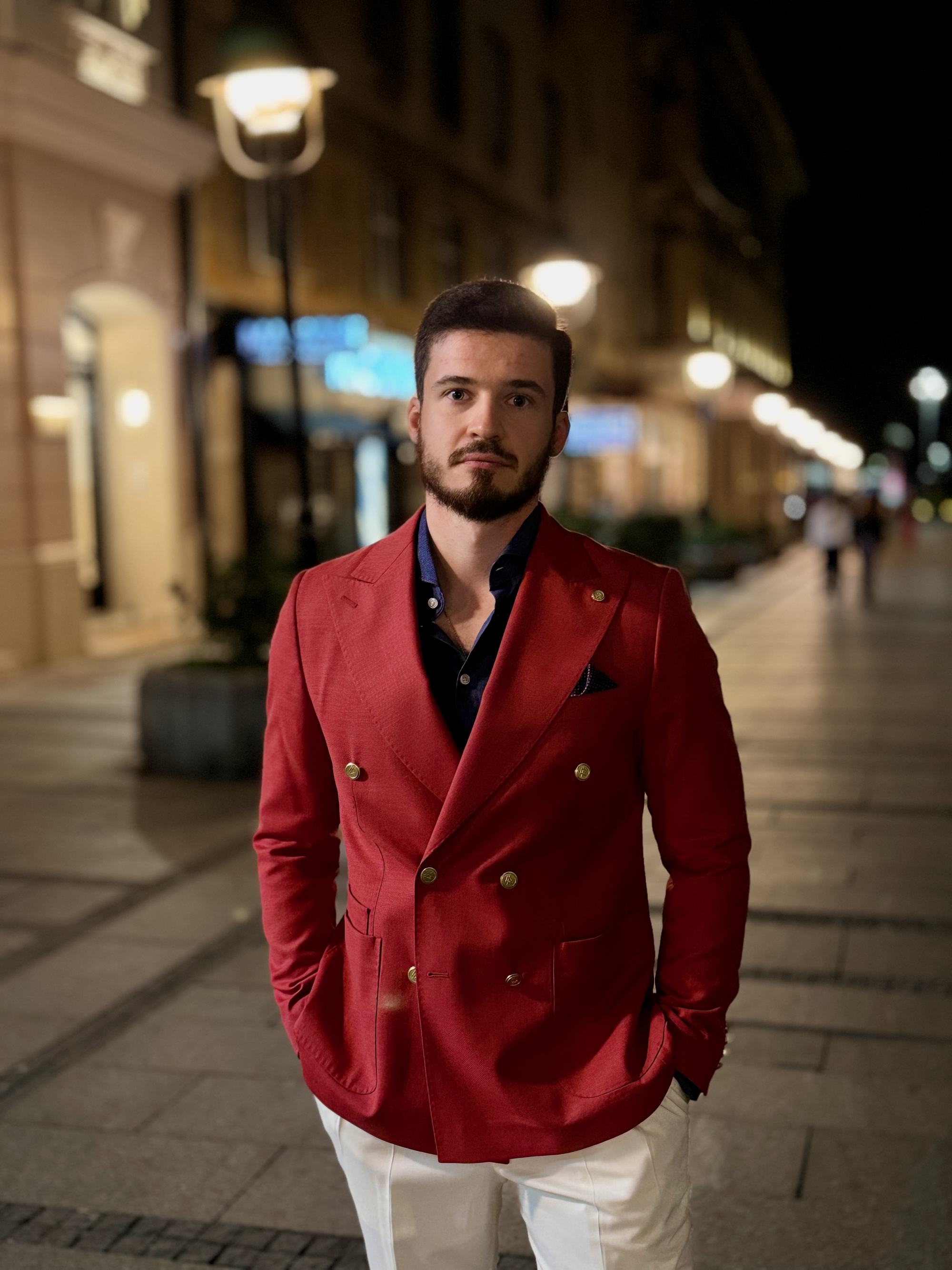 Personal stylist in a red double-breasted blazer on a Belgrade street at night